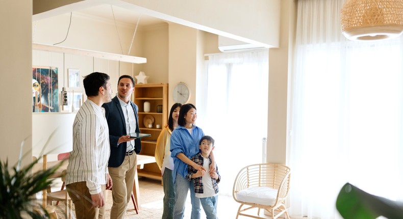 A family speaking with a real-estate agent.Anchiy/Getty Images