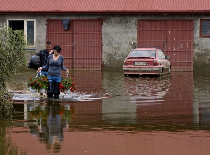 Marzena i Stanisław Czarneccy wynoszą suche, ocalałe rzeczy przed dom we wsi Wilków (woj. lubelskie)
