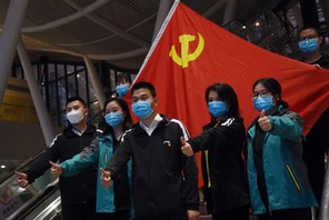 Medical workers from outside Wuhan pose for pictures with a Chinese Communist Party flag at the Wuhan Railway Station before leaving the epicentre of the novel coronavirus disease outbreak