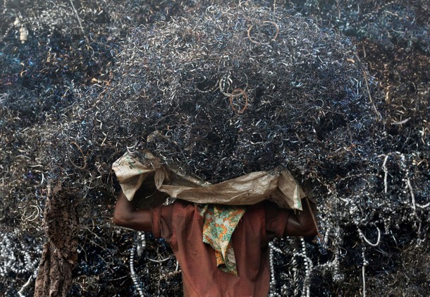 A labourer loads metal scrap onto a truck in an industrial area in Mumbai