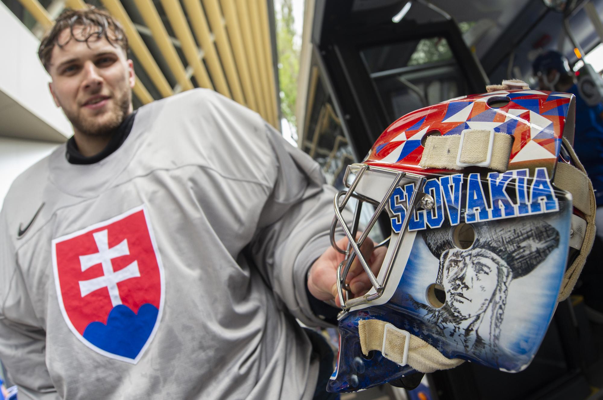 Slovenský hokejový reprezentant, brankár Samuel Hlavaj ukazuje svoju helmu, na ktorej má zobrazeného Juraja Jánošíka po tréningu.
