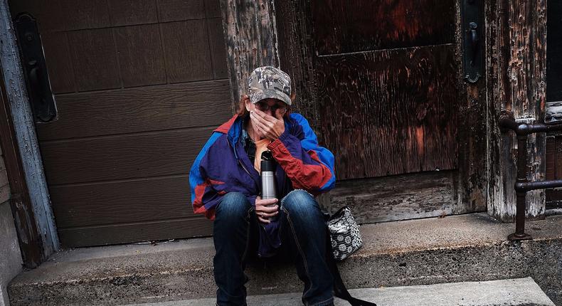 Dora Reynolds, who is currently unemployed, sits along a road downtown on October 24, 2016 in East Liverpool, Ohio