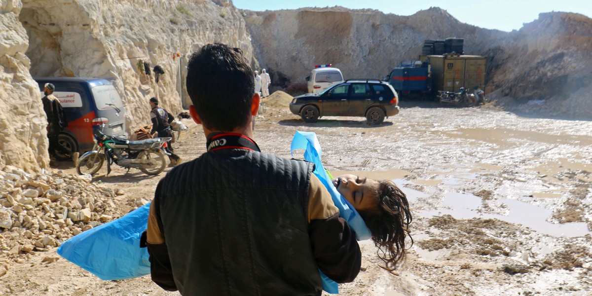 A man carries the body of a dead child, after what rescue workers described as a suspected gas attack in the town of Khan Sheikhoun in rebel-held Idlib, Syria, on April 4, 2017.