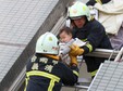 Rescue workers remove a baby from the site where a 17-storey apartment building collapsed after an earthquake hit Tainan