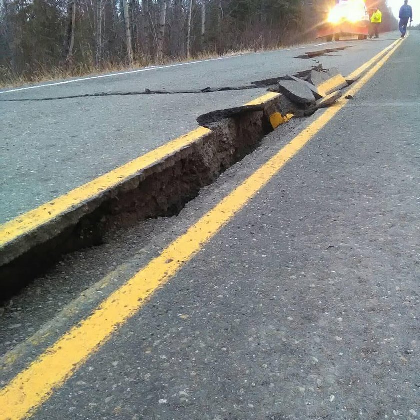 A vehicle lies stranded on a collapsed roadway near the airport after an earthquake in Anchorage