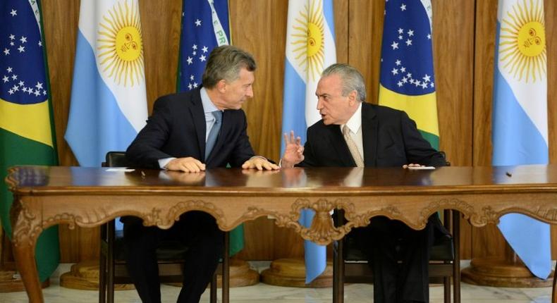 Brazilian President Michel Temer (R) and Argentina's President Mauricio Macri chat before signing bilateral agreements at the Planalto Palace in Brasilia on February 7, 2017