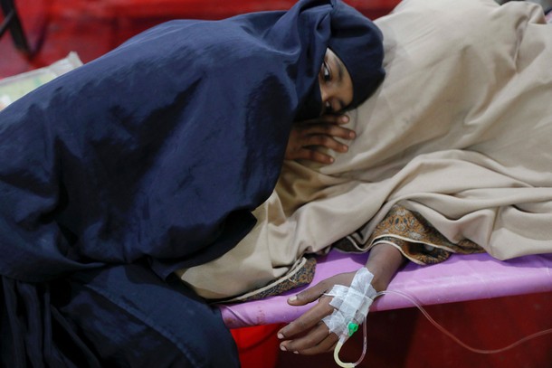 A woman comforts her husband suffering from severe diarrhoea at a dysentery clinic run by Medical Te