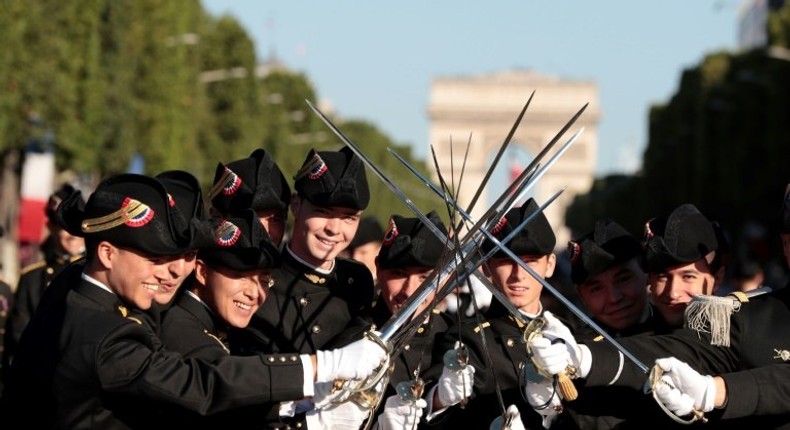 Pupils of the Ecole Polytechnique, promotion X2016, cross their sowrds as they wait for the start of the annual Bastille Day military parade on the Champs-Elysees avenue in Paris, on July 14, 2017