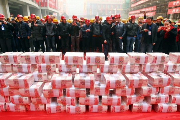 Migrant workers wait to collect their salary and bonus ahead of the Spring Festival at a constructio