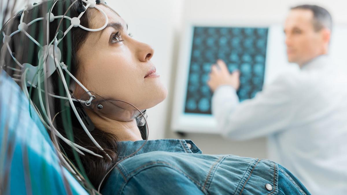 Charming young woman undergoing electroencephalography