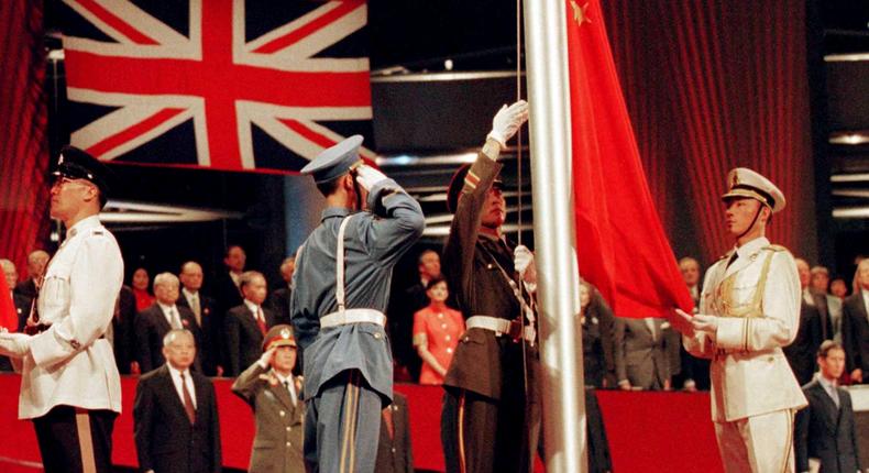 The Chinese flag is raised by People's Liberation Army soldiers to signal Hong Kong's return to Chinese sovereignty after 156 years of British rule, in Hong Kong, July 1, 1997.