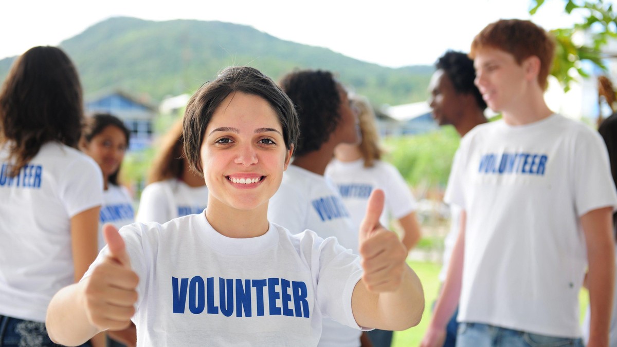 happy volunteer girl showing thumbs up sign