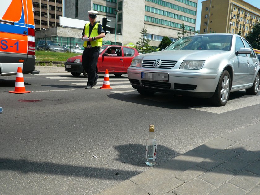 butelka wódki na ulicy i policjant z drogówki