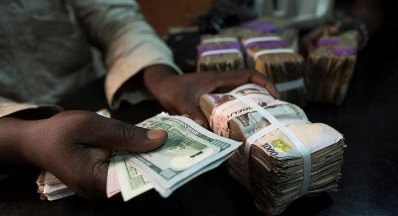 A trader changes dollars with naira at a currency exchange store in Lagos, Nigeria, February 12, 2015. REUTERS/Joe Penney