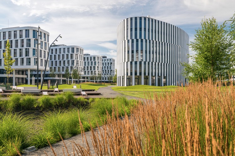 Business Garden to wyjątkowy kompleks biurowy umiejscowiony pośród naturalnej zieleni u zbiegu ulic 1 Sierpnia oraz Żwirki i Wigury w Warszawie, należący do firmy Vastint. Jest to jedna z najważniejszych i największych biurowych inwestycji zbudowanych w stolicy w ostatnich latach. Przyjrzyjmy się bliżej temu imponującemu kompleksowi.”