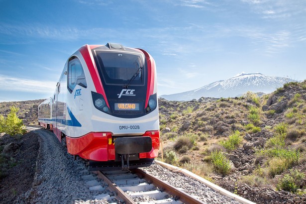 Pociąg Vulcano Newagu dla przewoźnika FCE. W tle wulkan Etna