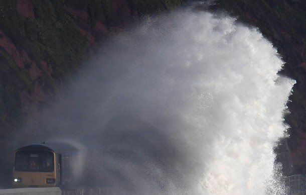 Waves hit a train during heavy seas and high winds in Dawlish in south west Britain