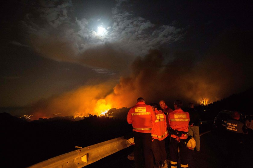 Flames and smoke from a forest fire are seen in the village of Valleseco