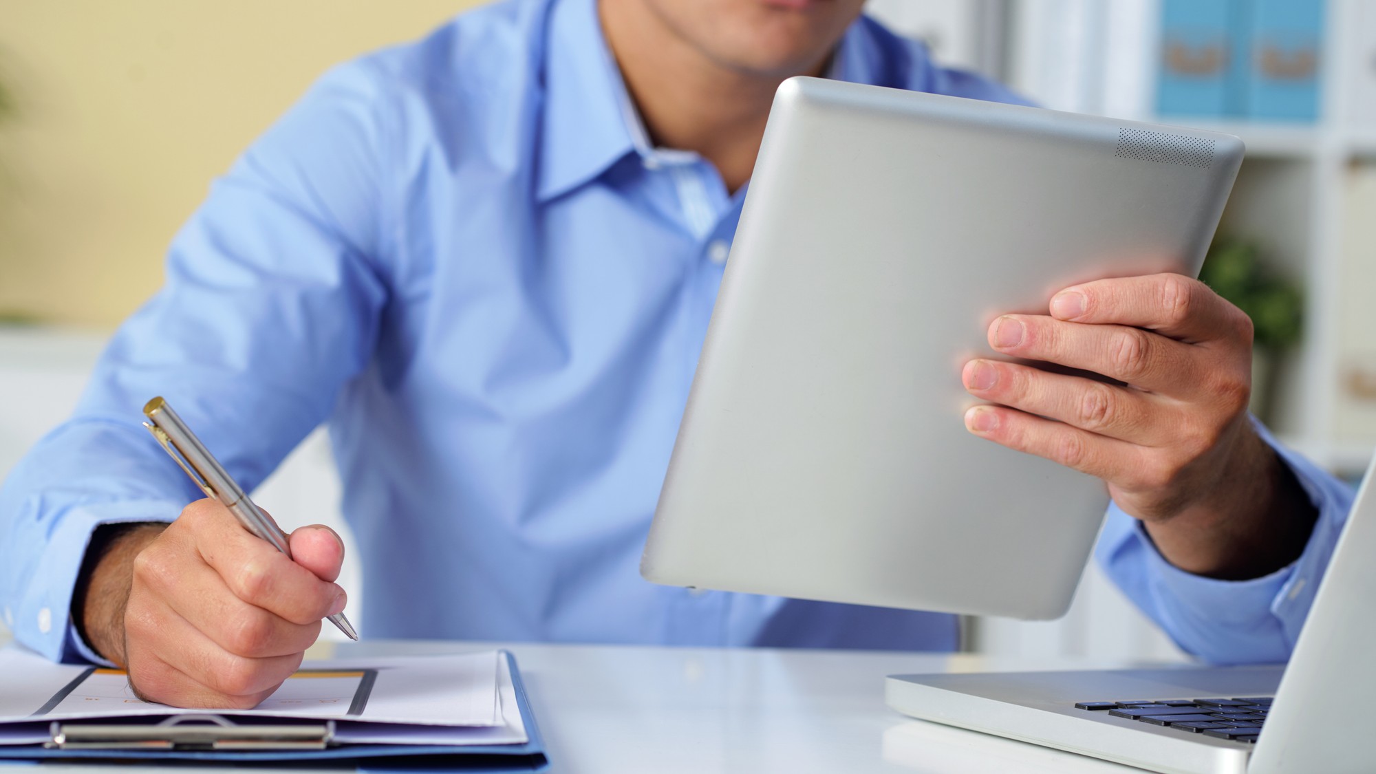 Pracovník dopravného inšpektorátu spracováva dokumenty k prepisu vozidla. 