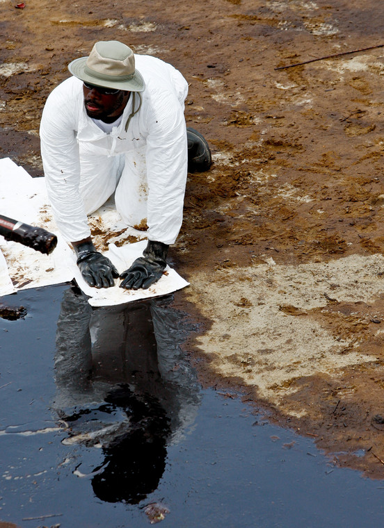 Katastrofa w Zatoce Meksykańskiej: Grand Isle, Louisiana, USA. Pracownicy zatrudnieni przez koncern BP przy użyciu wchłaniających ropę szmat czyszczą plażę z resztek czarnej mazi. Foto: Derick E. Hingle/Bloomberg