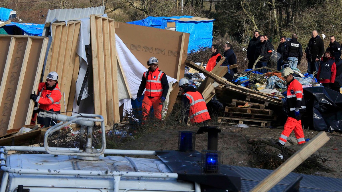 Workmen tear down makeshift shelters during the partial dismantlement of the camp for migrants called the "jungle", in Calais