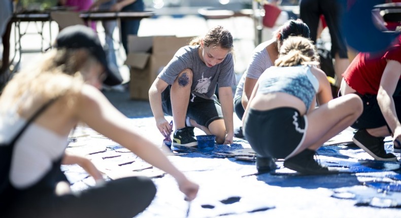 Nora Gell (center), 14, paints cardboard waves in Brooklyn on September 15, 2019 for the climate strike protests planned for September 20