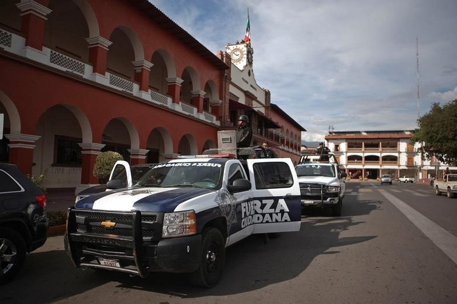 Police stand guard outside the town hall after a shooting between federal forces and armed civilians in the town of Apatzingan, Michoacan.