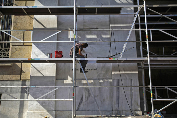Grecja; pracownik budowlany na rusztowaniu przed budynkiem greckiego banku centralnego w Atenach