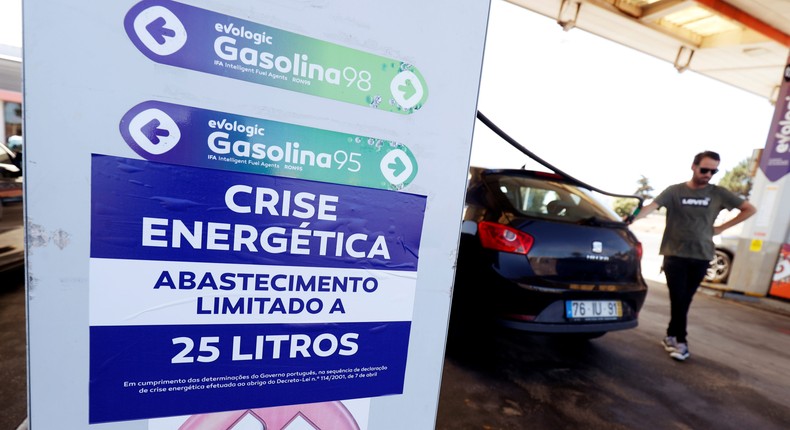 FILE PHOTO: A placard reading Energy crisis. Maximum limit 25 litres per filling is seen as a man fills up a car during a fuel strike, at a gas station near Lisbon