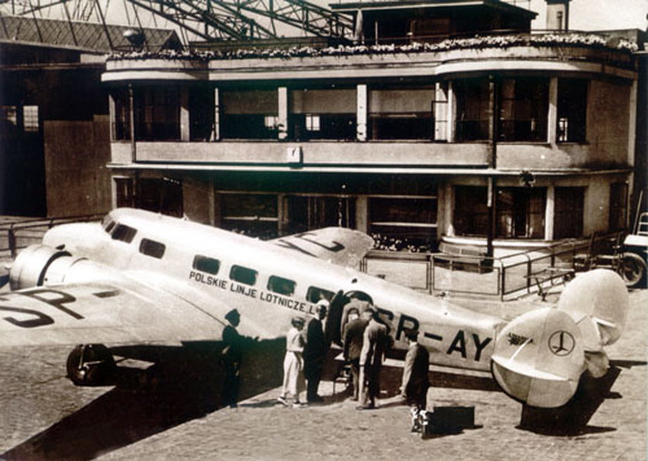Lockheed L-10 Electra na lotnisku Okęcie. Pasażerowie w trakcie boardingu czekają w kolejce do wejścia. 