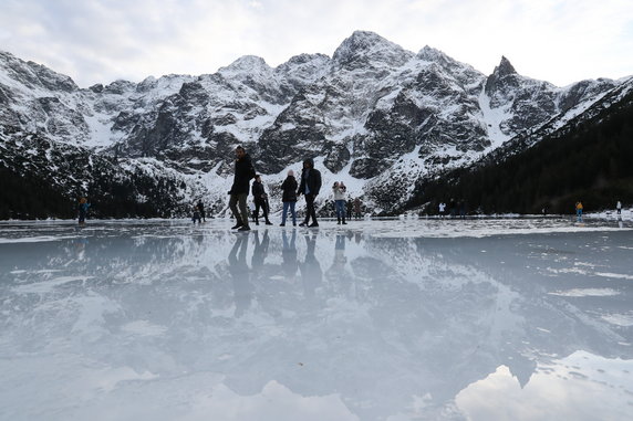 Turyści na tafli lodu na jeziorze Morskie Oko w Tatrach