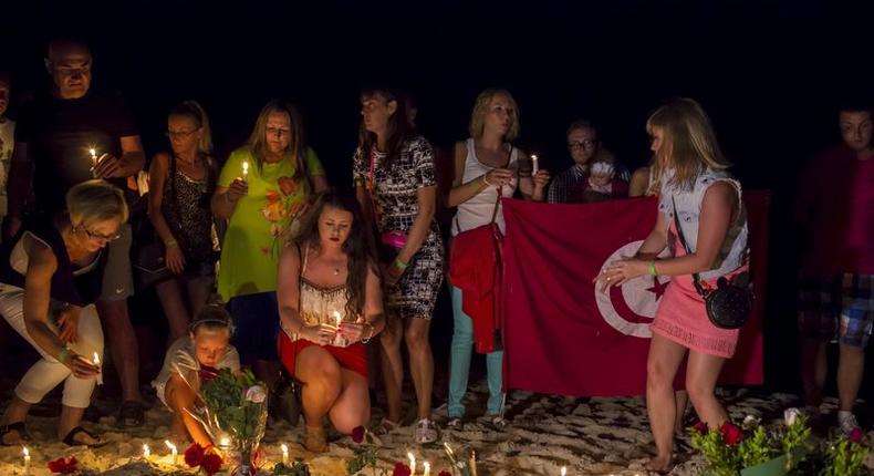 People place lit candles in the sand in front of the Imperial Marhaba Hotel, where a gunman had carried out an attack, in Sousse, Tunisia, June 28, 2015. REUTERS/Zohra Bensemra