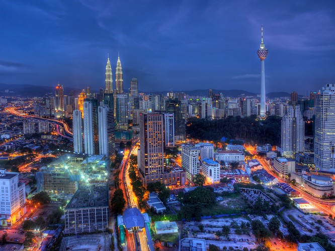 Panorama Kuala Lumpur w nocy. Z prawej widoczna wieża telewizyjna Menara Kuala Lumpur o wysokości 421 m. Jest drugą, po Petronas Towers, najwyższą budowlą miasta i 20. najwyższym wolno stojącym obiektem budowlanym na świecie. Na kolejnym zdjęciu pokazujemy, jaki widok rozciąga sięz wieży telewizyjnej. Fot. Hafiz Ismail / Shutterstock.com