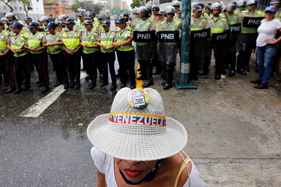 An opposition supporter in front of the police during a rally to demand a referendum to remove President Nicolas Maduro in Caracas on July 27.