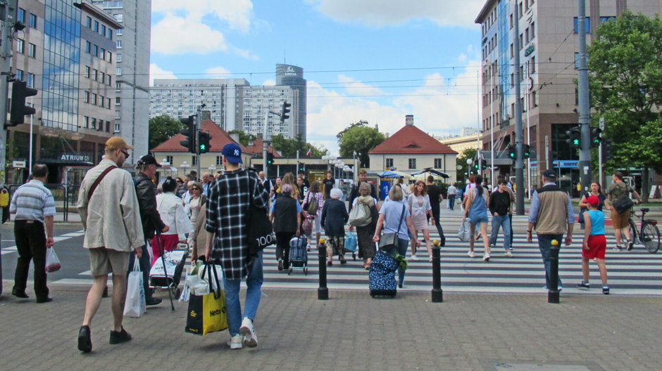 Ludzie na przejściu dla pieszych w Warszawie