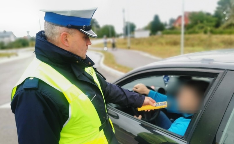 Policjant kontroluje trzeźwość kierowcy