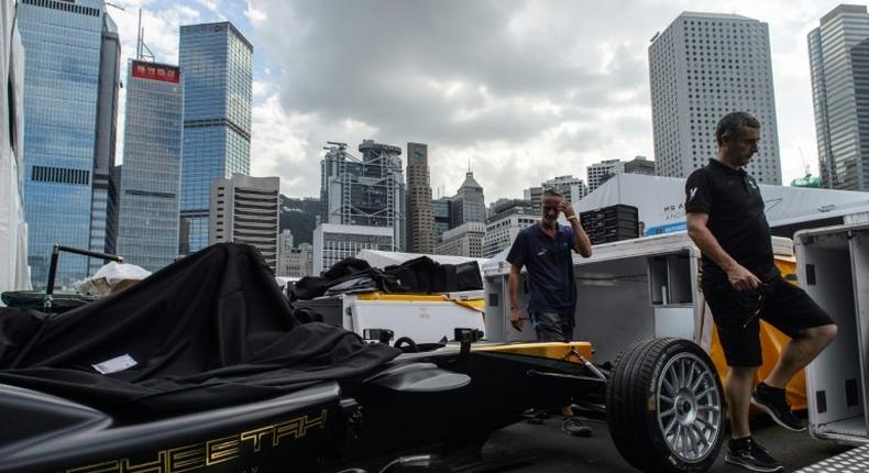 A Techeetah car is seen as other team members walk past in the pit lane of the Formula E track in Hong Kong