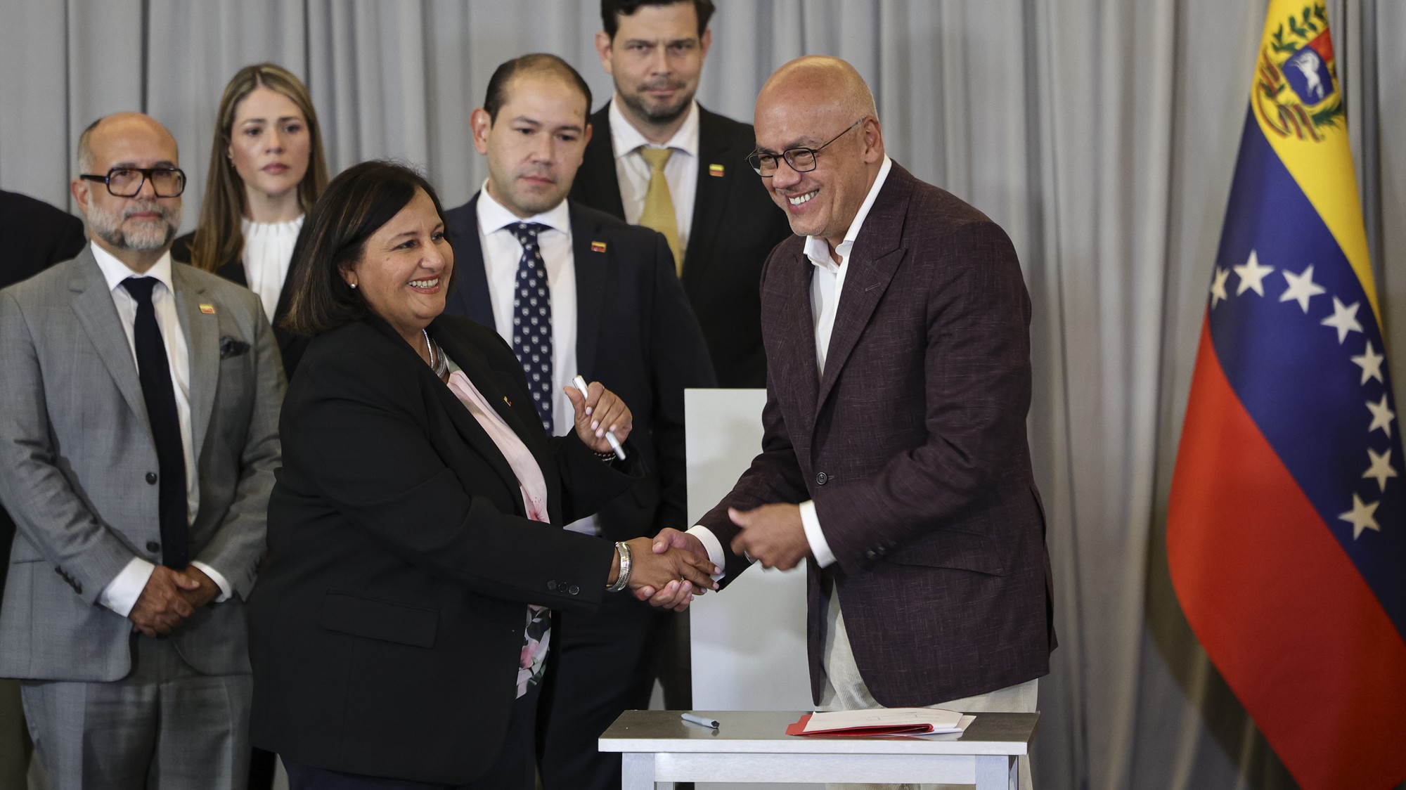 Predseda Národného zhromaždenia Jorge Rodríguez a predstaviteľka venezuelskej opozície Dinorah Figuera si podávajú ruky po podpísaní dohôd na záver druhého kola politických rokovaní v Caracase vo Venezuele.
