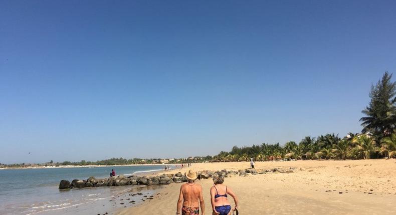 Tourists take a morning stroll along the beach in Saly, a coastal resort town in Senegal popular with Western tourists, March 15, 2016. REUTERS/Edward McAllister