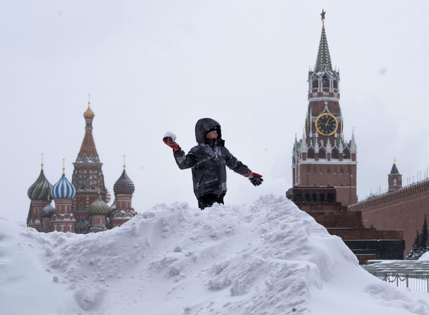 Workers remove snow in a street in Moscow