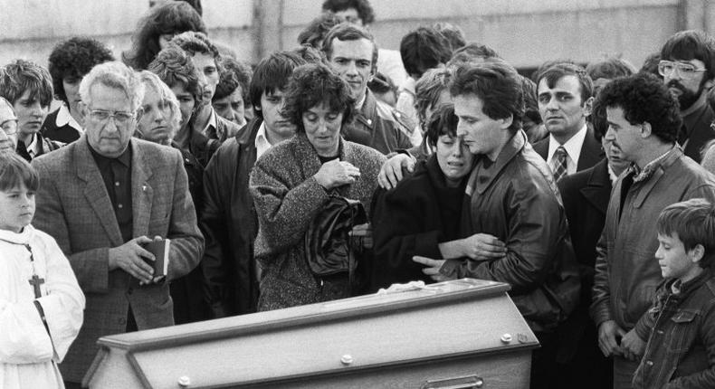 This photo taken on October 20, 1984 in Lepanges-sur-Vologne shows Christine and Jean-Marie Villemin (foreground 4R and 5R) crying in front of the coffin of their son during a funeral ceremony Three members of the Villemin's family were placed in custody on June 14, 2017 as part of the inquiry into the case of Gregory. The body of Gregory Villemin was found with his hands and feet bound, on October 16, 1984, in the river.