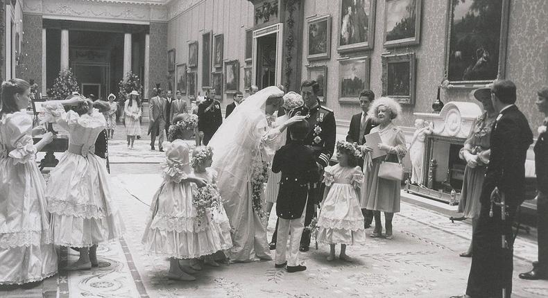 The newly-married couple stop to speak to their page boys and bridesmaids as the Queen Mother (right) looks on