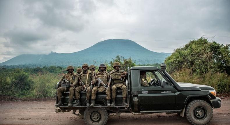 A Congolese army pick up carrying trooops heads towards the front line near Kibumba in the area surrounding the North Kivu city of Goma on May 25, 2022 during clashes between the Congolese army and M23 rebels. - DR Congo soldiers fought M23 militiamen on several fronts in the troubled east of the country Wednesday, military and local officials said, with the government appearing to implicate Rwanda in the violent flare-up. (Photo by ARLETTE BASHIZI/AFP via Getty Images)