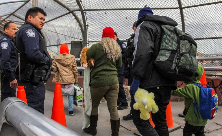 US Customs and Border Protection agents allow access for a group of 33 migrants who want to request political asylum in the United States, at the Paso del Norte International Bridge in Ciudad Juarez, Mexico, across from El Paso, Texas