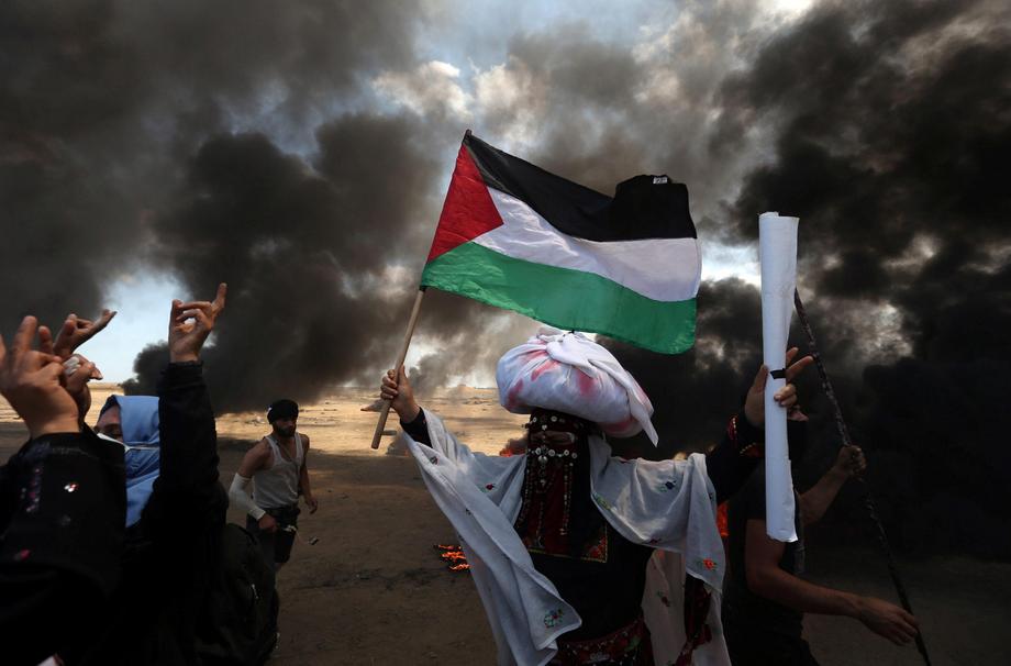 Female demonstrator holds a Palestinian flag during a protest against U.S. embassy move to Jerusalem