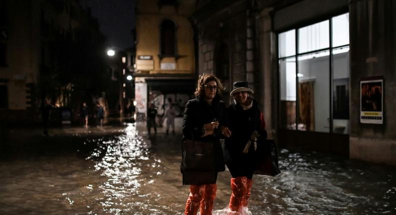 People cross a flooded street during an exceptional acqua alta on November 12 in Venice