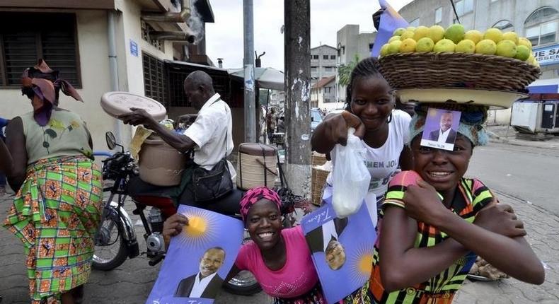 Street vendors hold campaign posters for presidential candidate Patrice Talon ahead of the second round of Benin's presidential election on Sunday in Cotonou, Benin, March 18, 2016. REUTERS/Charles Placide Tossou