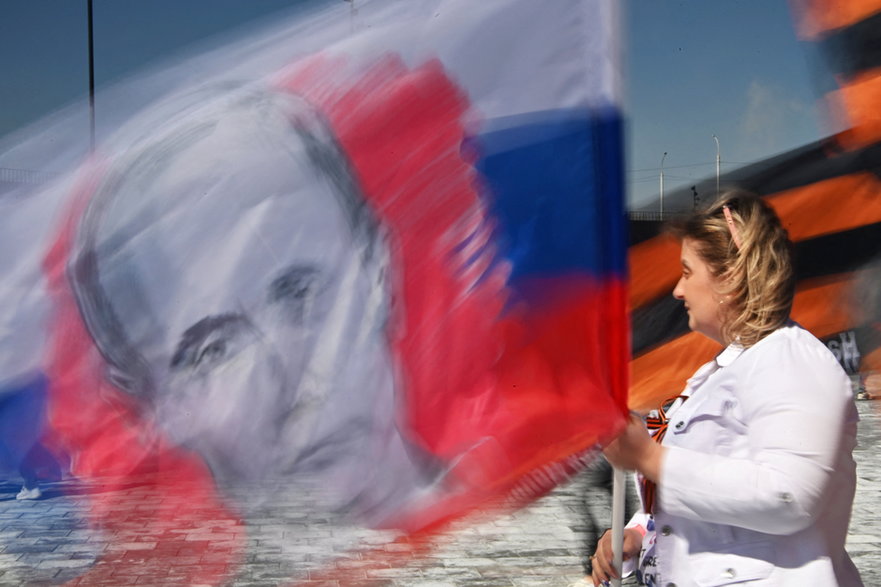 Kobieta z flagą z wizerunkiem Władimira Putina, 1 maja 2023 r.