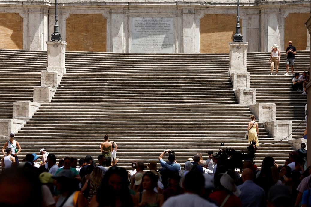 Turyści wolą pozostać w cieniu, niż spacerować po Hiszpańskich Schodach w Rzymie, 18 lipca 2023 r.