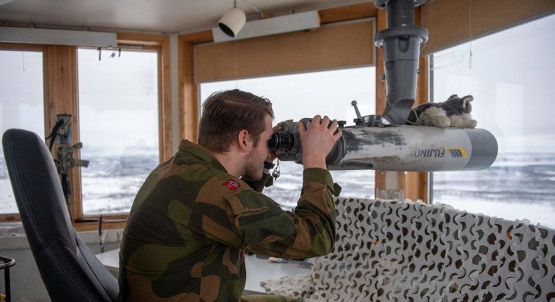 Norwegian soldier Vegard Aalbretsen looks through binoculars out towards the Russian border from Korpfjell's OP tower (observation post) in Kirkenes, northern Norway, on February 24, 2022.ANNIKA BYRDE via Getty Images